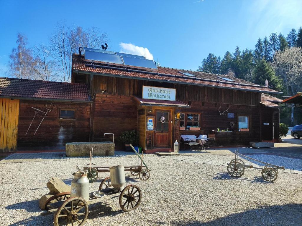 three antique tractors in front of a wooden building at Chalet Waldstadl oder Andrea's Woidhaisl in Arnbruck