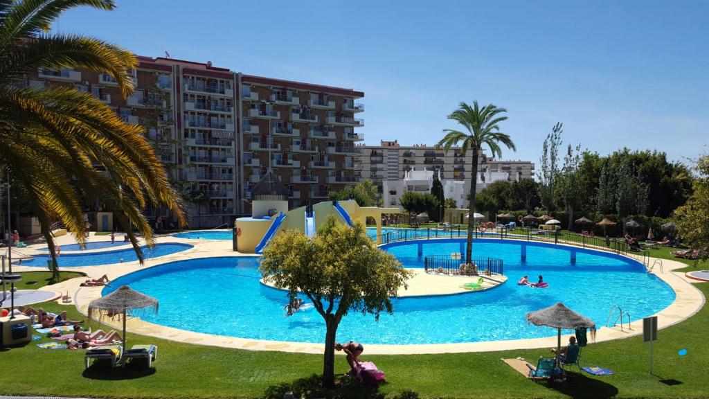 a large swimming pool with people in a resort at Minerva 242 in Benalmádena