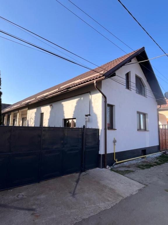 a white house with a black fence at Casa Boitor in Jidvei
