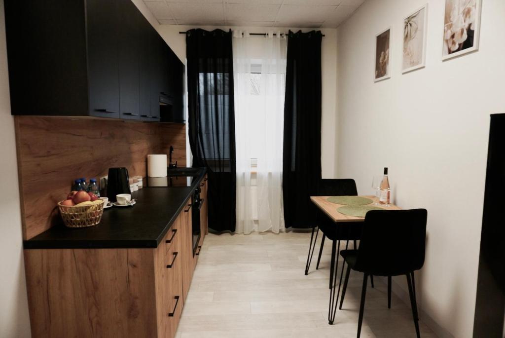a kitchen with a counter and a table with chairs at Nowoczesny Apartament w Prudniku in Prudnik