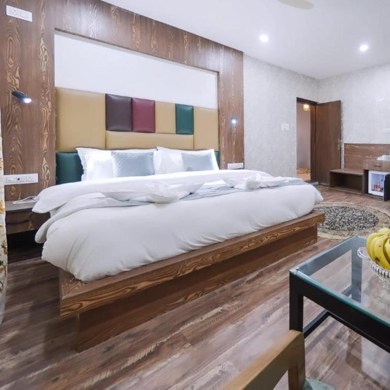 a bedroom with a large bed with a wooden headboard at Hotel Your Hive in Srinagar