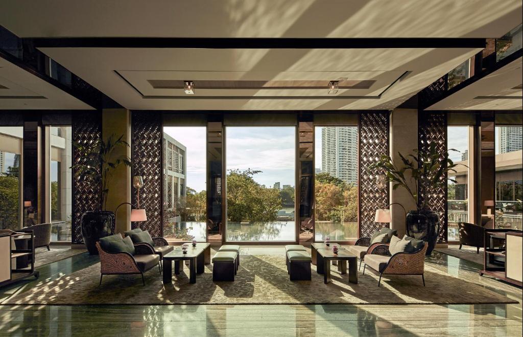 A light-filled lobby lounge faces a central water view through tall windows.
