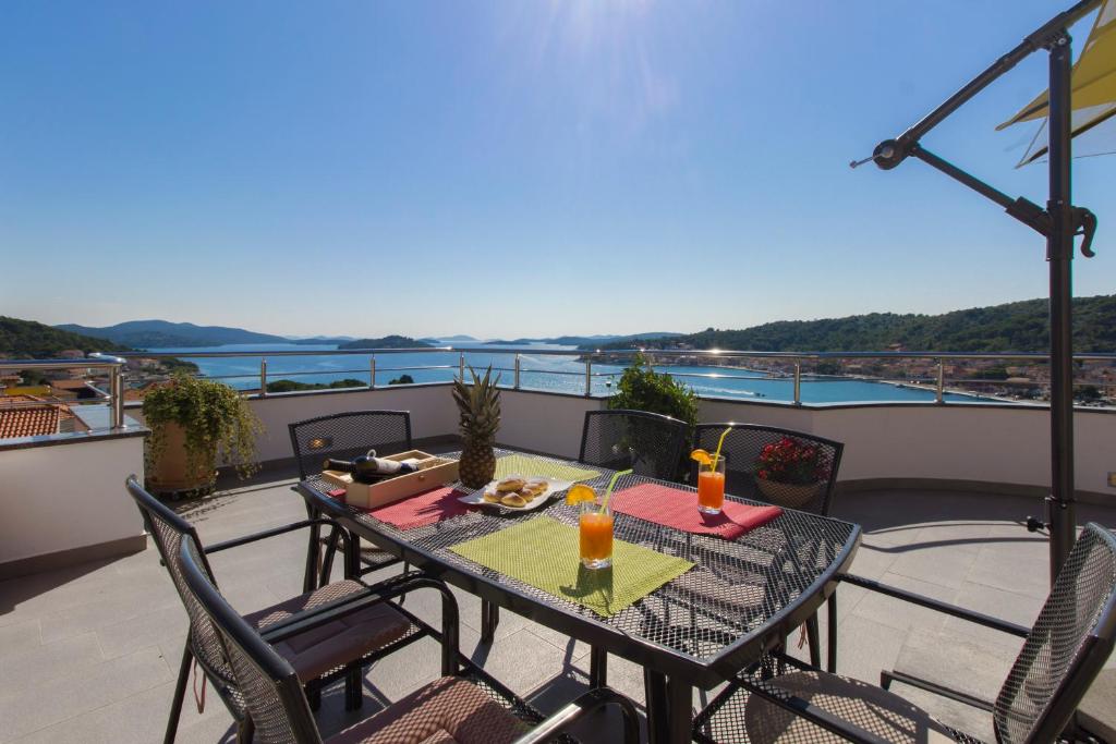 a table and chairs on a balcony with a view at Apartments Matea in Tisno