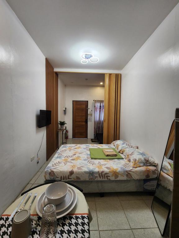 a bedroom with a bed and a table with plates on it at Caishen Apartelle The Couples Getaway in Silang
