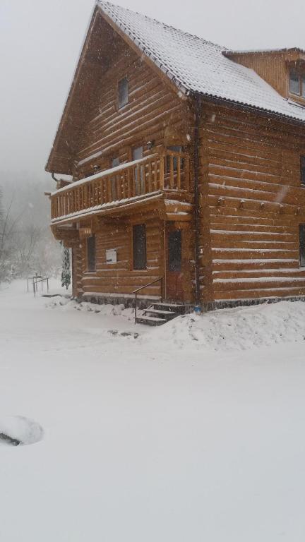a log cabin in the snow with snow at Valea Vistisoarei in Vistisoara