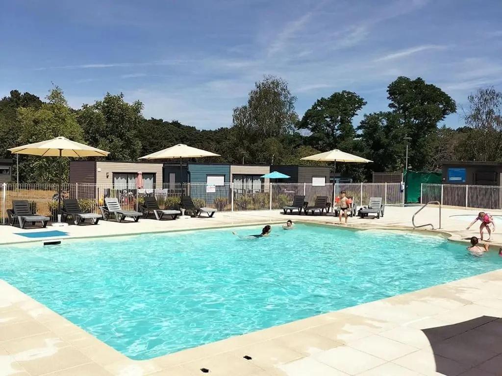 a group of people in a swimming pool at ZEcamping 3 étoiles animaux acceptés piscine et restaurant in Pluherlin