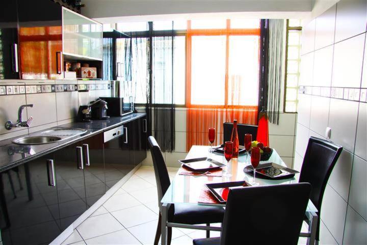 a kitchen with a table and chairs in a kitchen at Fernandes Apartment in Carvoeiro