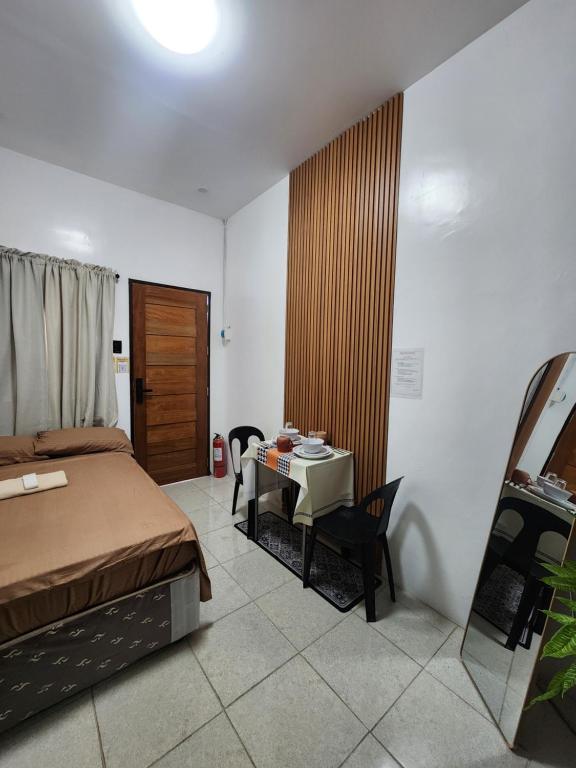 a bedroom with a bed and a table and a table and chairs at Caishen Apartelle The Traveler Accomodation in Biga
