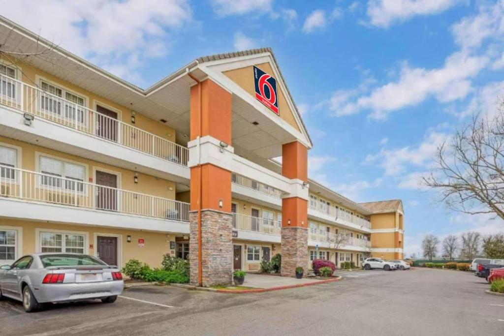 a hotel exterior with a car parked in a parking lot at Studio 6 Suites Sacramento Northgate CA in Sacramento