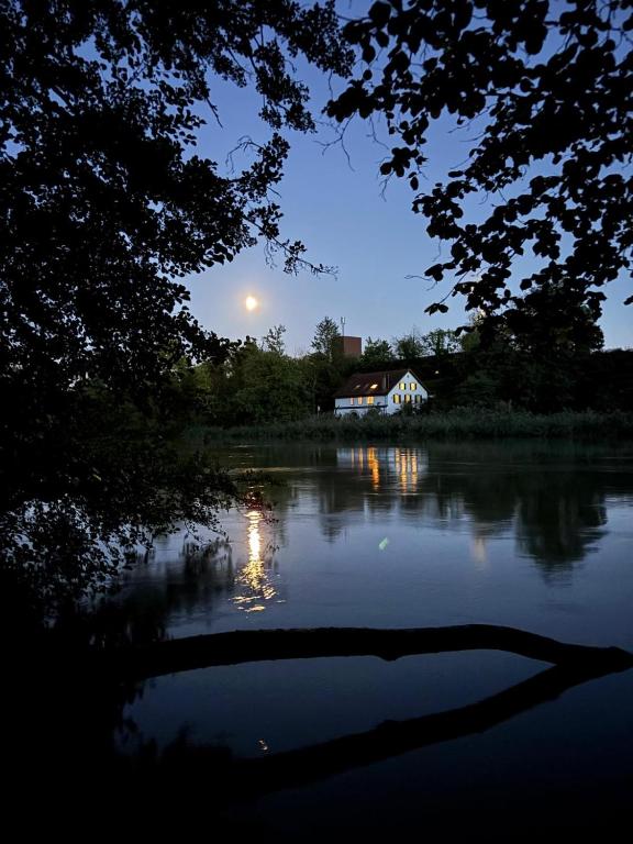 a house on the shore of a river at night at Studio im Naturschutzgebiet in Spreitenbach