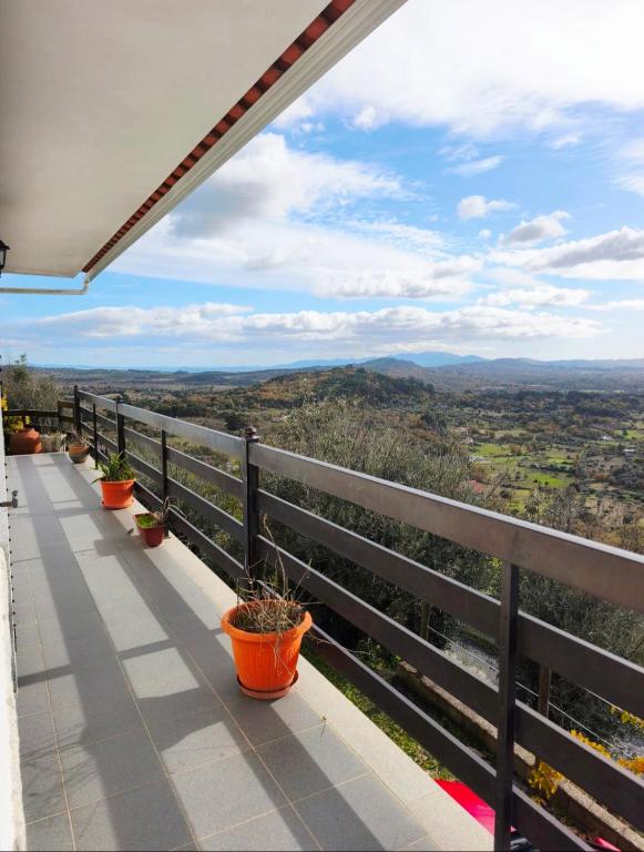 a balcony with potted plants and a view of the mountains at Aurélio & Zezinha House in Penamacor