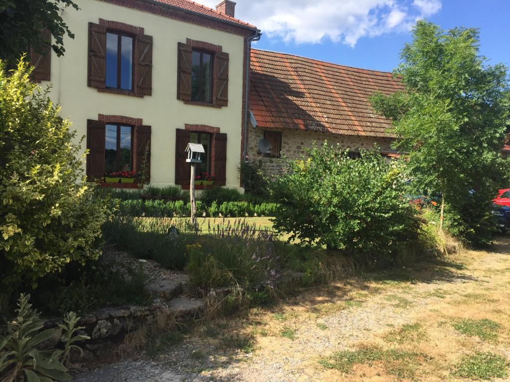 an old house with a red roof at Grande maison entre vert et bleu in Saint-Yrieix-la-Montagne