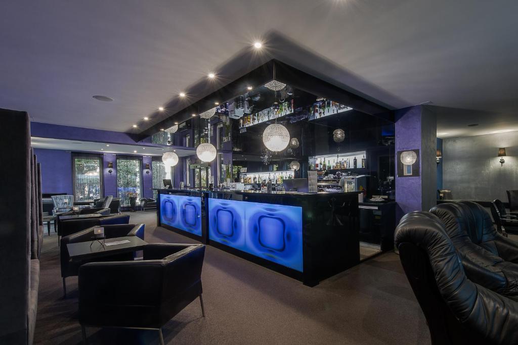 a bar with couches and a bar with blue lights at Hotel Polo in Prešov