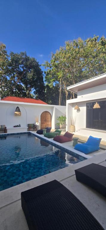 a swimming pool with lounge chairs next to a house at Stars Villa in Ngingas
