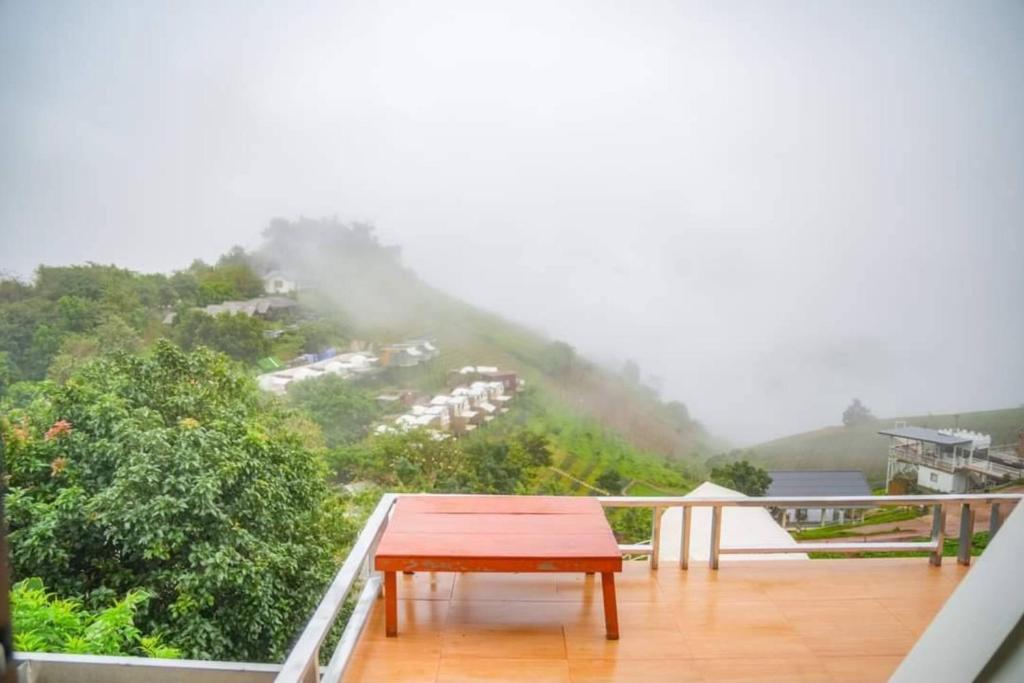 a table on a balcony with a view of a mountain at Mon Mon Homestay in Mon Jam