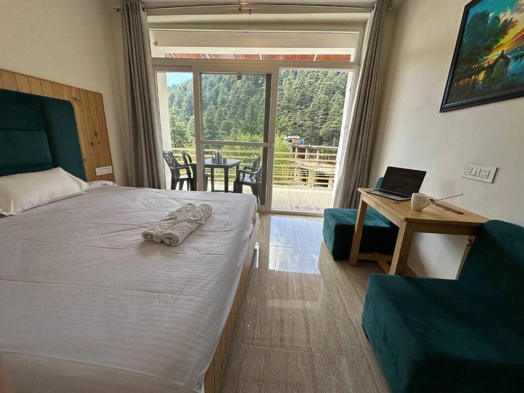 a bedroom with a bed and a desk with a laptop at OmiHomeStay Dharamkot McLeodganj in Dharamshala