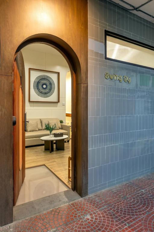 an entry way to a living room with a blue tile wall at Swing By in Bangkok