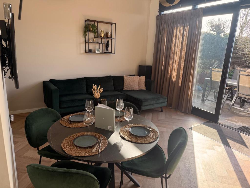 a living room with a table and chairs and a couch at Cozy & Modern Tiny House in Velserbroek 