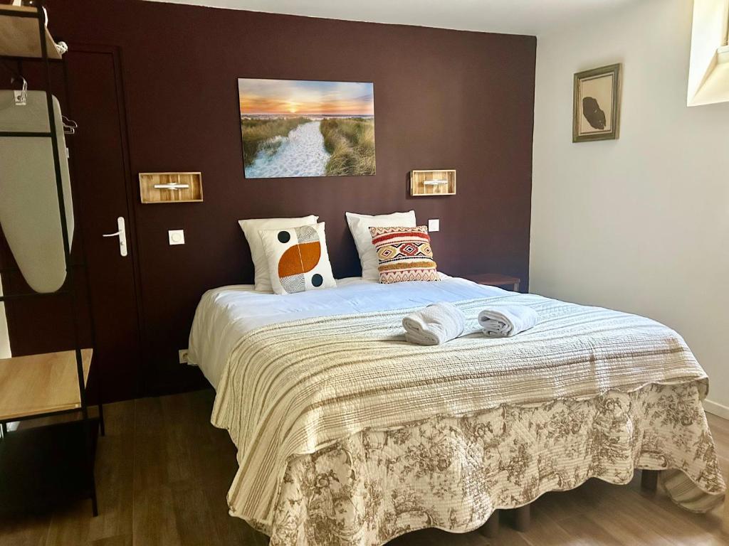 a bedroom with a large bed with a blanket at L'Escale à Villerville in Villerville