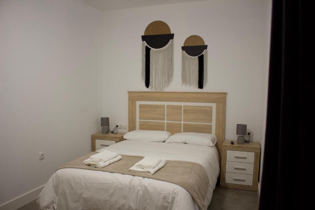 a bedroom with a bed with two towels on it at Apartamentos Lumael in Mérida
