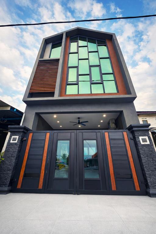 a tall building with a large doorway with glass windows at AH Homes Kulai in Kulai