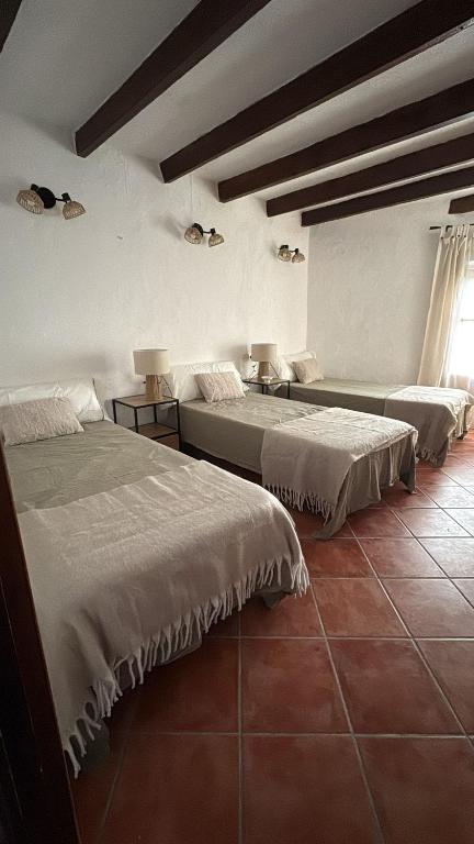 a bedroom with two beds and a window at Casa Rural La Font in Sant Mateu