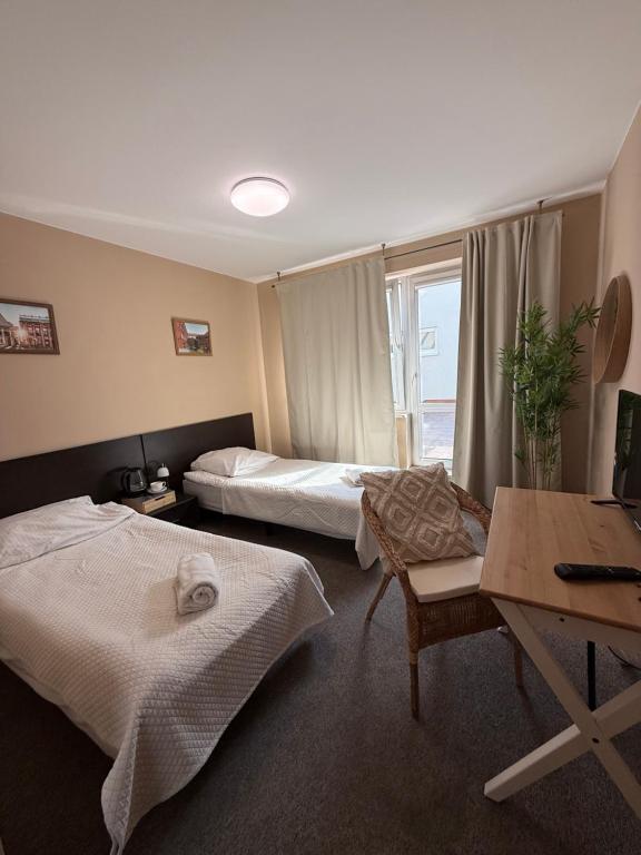 a hotel room with two beds and a table at Hotel Aqua Żyrardów in Żyrardów