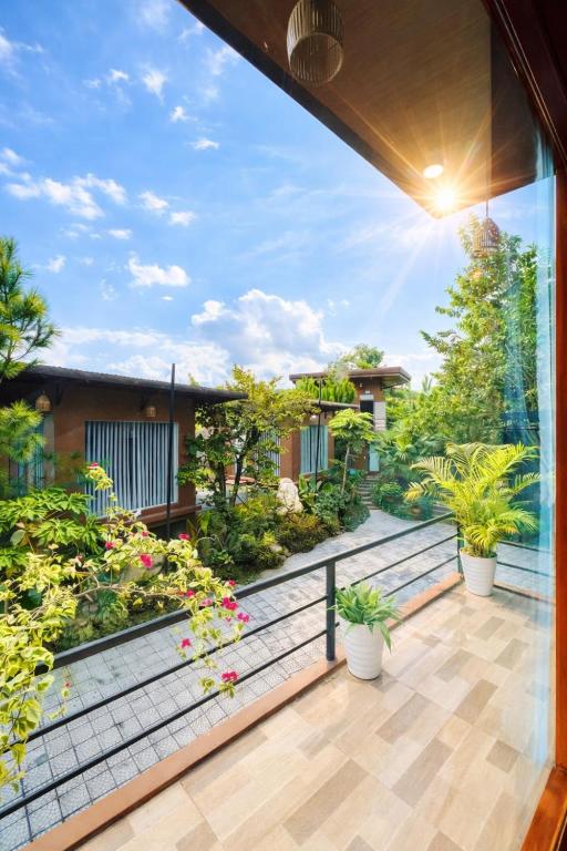 a balcony of a house with potted plants at White Horse Homestay in Hue