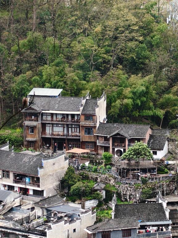 a group of buildings with roofs on a mountain at Xinsu Courtyard View GuestHouse in Fenghuang County