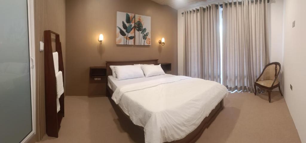a bedroom with a large white bed and a window at Meneth Villa in Hatton