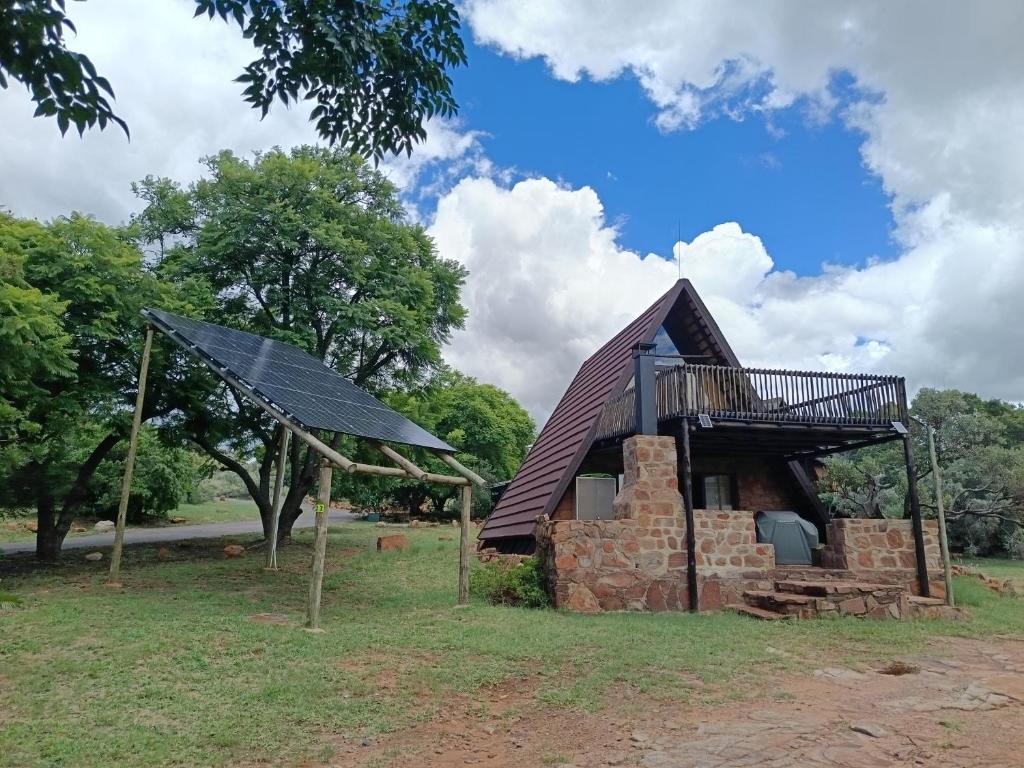 a house with a roof on top of a pile of bricks at Cosy Cottage in Buffelspoort