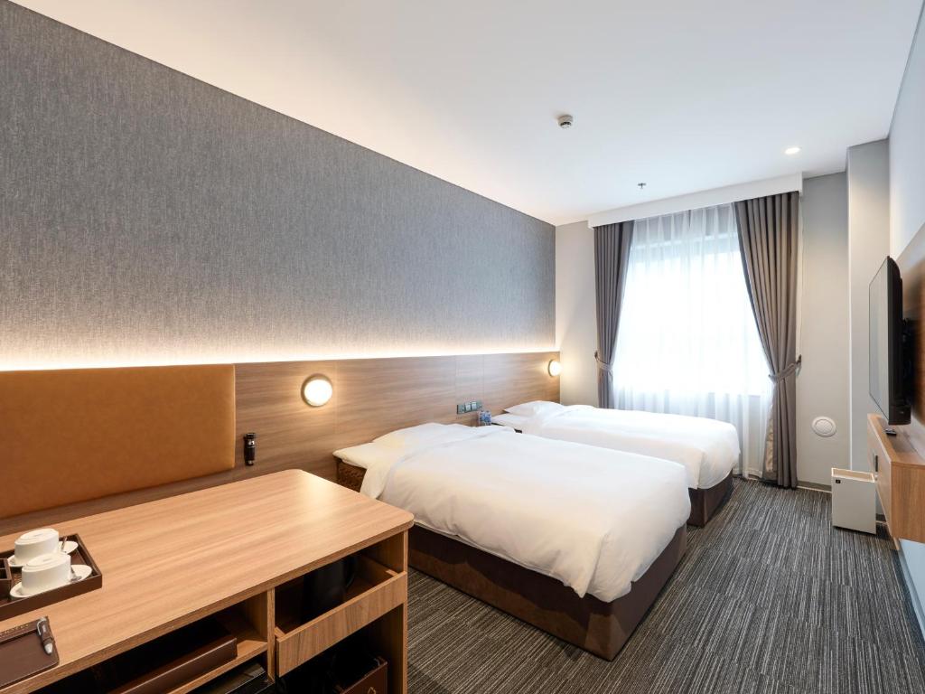 a hotel room with two beds and a desk at SUPER HOTEL HANOI - Grand Opening in 17 March 2026 in Hanoi