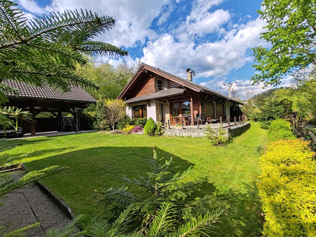 a house with a green yard in front of it at Apartmany Janosikove diery in Terchová