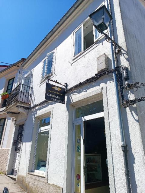 a white building with a street light in front of it at mundoalbergue in Santiago de Compostela
