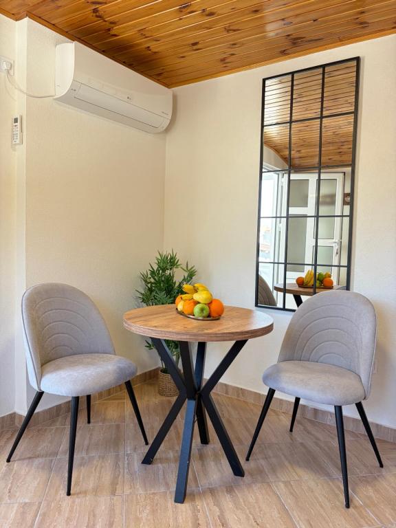 a table with two chairs and a bowl of fruit on it at Verica in Dobrota