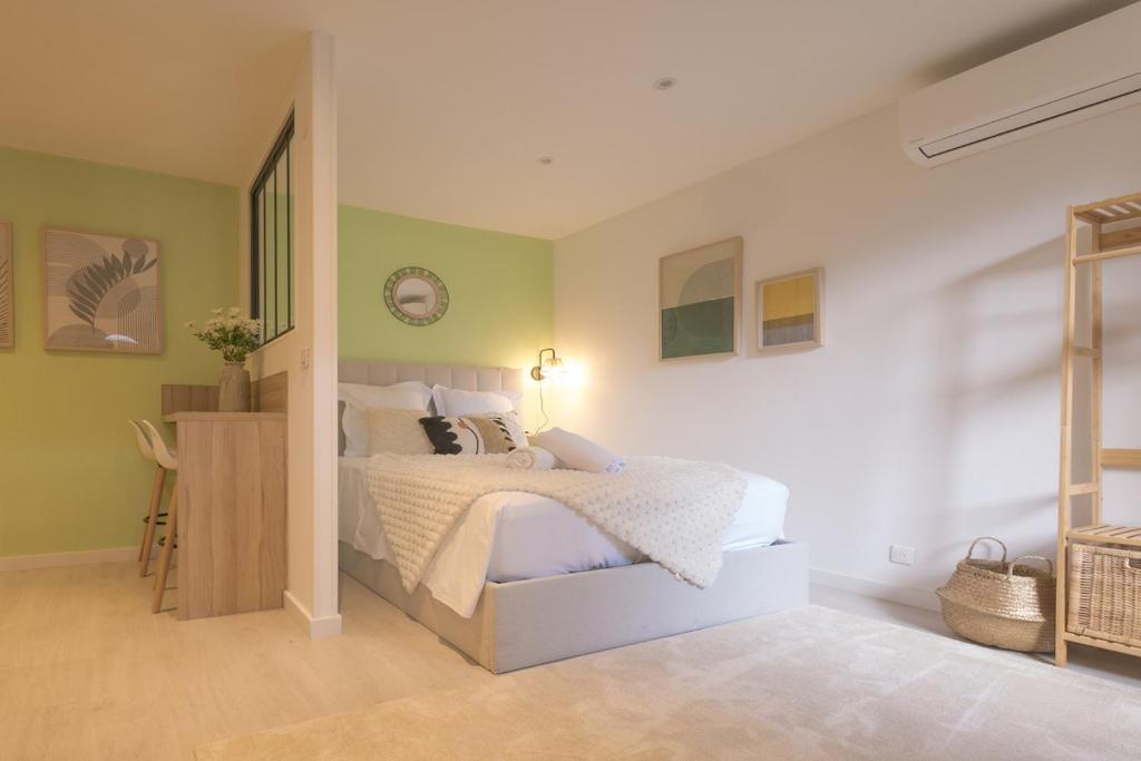 a bedroom with a bed with white sheets and green walls at Le Nid Vert - air conditioning - ground floor in Bourg-en-Bresse
