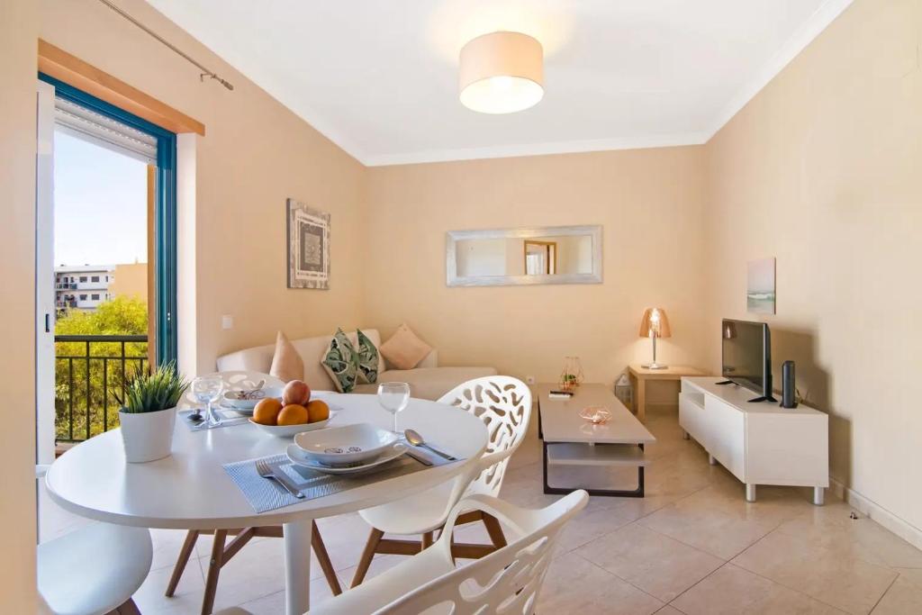 a living room with a table and a couch at Almancil Park Apartment in Almancil
