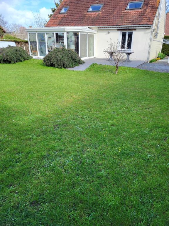 a house with a yard with a green lawn at LES CANAILLOUS 4 clos la fossette Asnelles in Asnelles