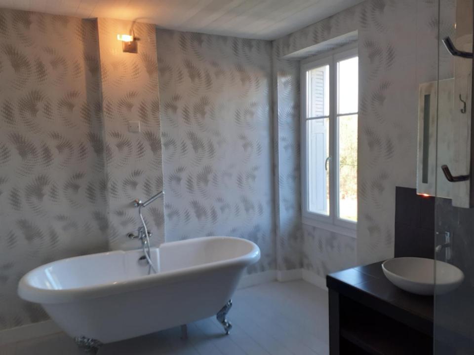 a white bathroom with a tub and a sink at Les Ombelles in Saint-Estèphe