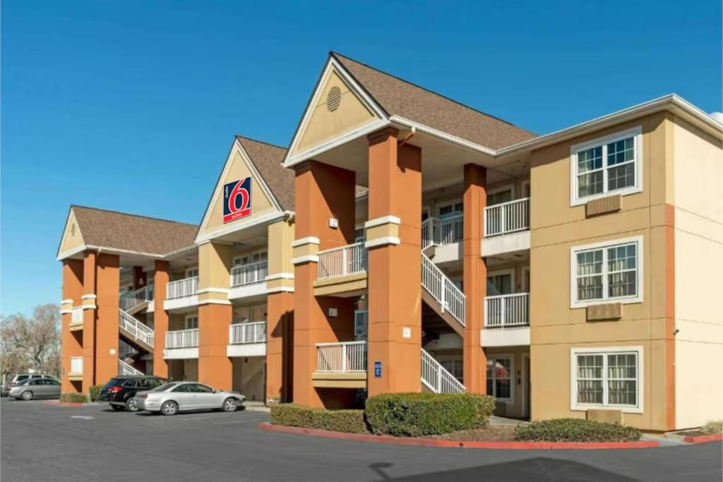 a large apartment building with cars parked in a parking lot at Studio 6 Extended Stay Sacramento Arden Way CA in Sacramento