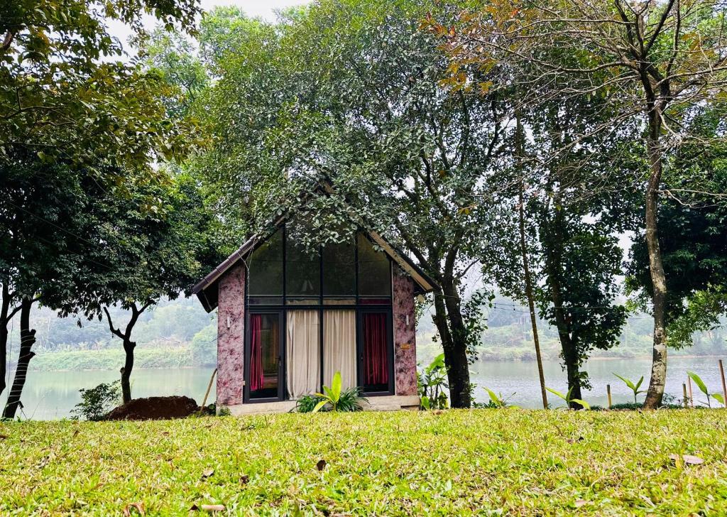 a small house sitting on top of a grass field at Maisonson Resort in Dương Kê
