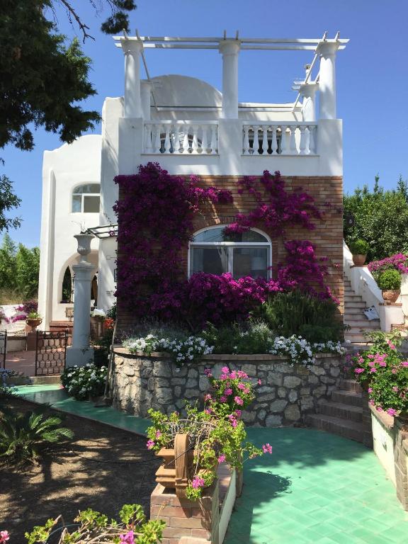 a white house with flowers in front of it at Villa Croce Anacapri in Anacapri