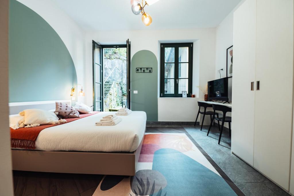a bedroom with a bed and a dining room at Cà del Lasco - Free parking apartments 5 min from the station in Bellano