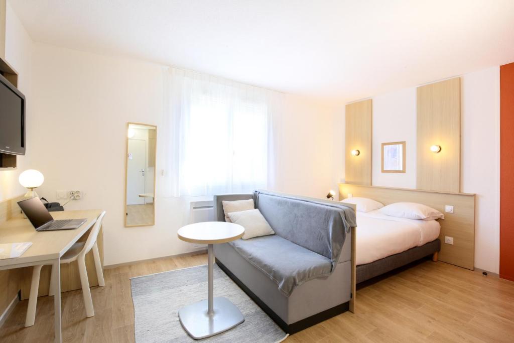 a bedroom with a bed and a chair and a desk at Sweetly Isatis Mérignac Hôtel de ville in Mérignac