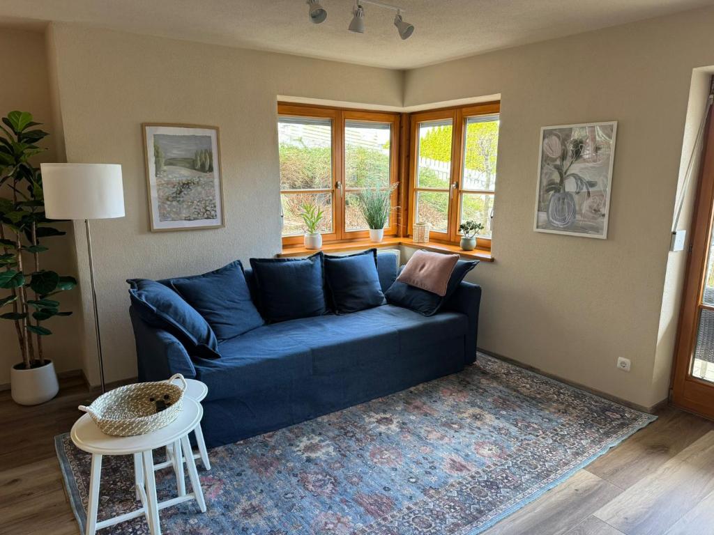 a living room with a blue couch and a table at Modernes Apartment zum wohlfühlen und entspannen, max 4 Personen, Top Ausstattung in Trunkelsberg