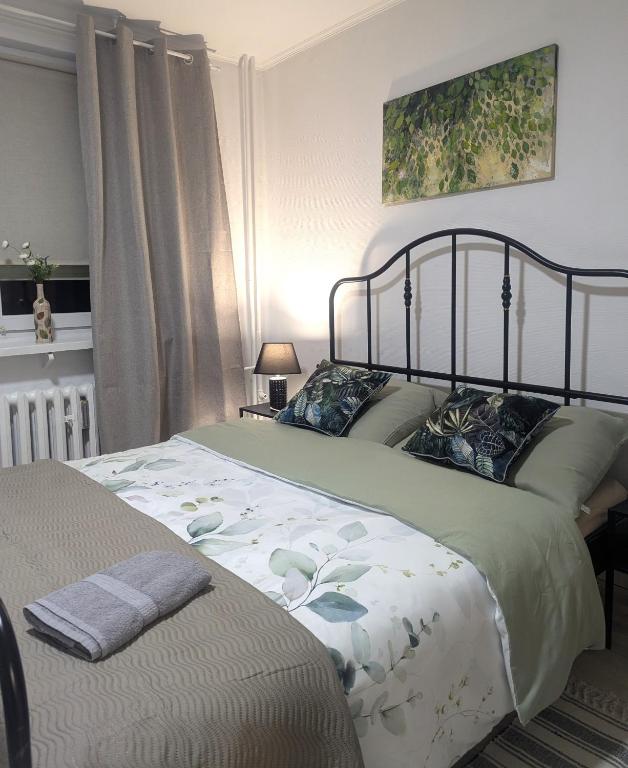 a bedroom with a large bed with a flower patterned blanket at Smart Centrum in Konin