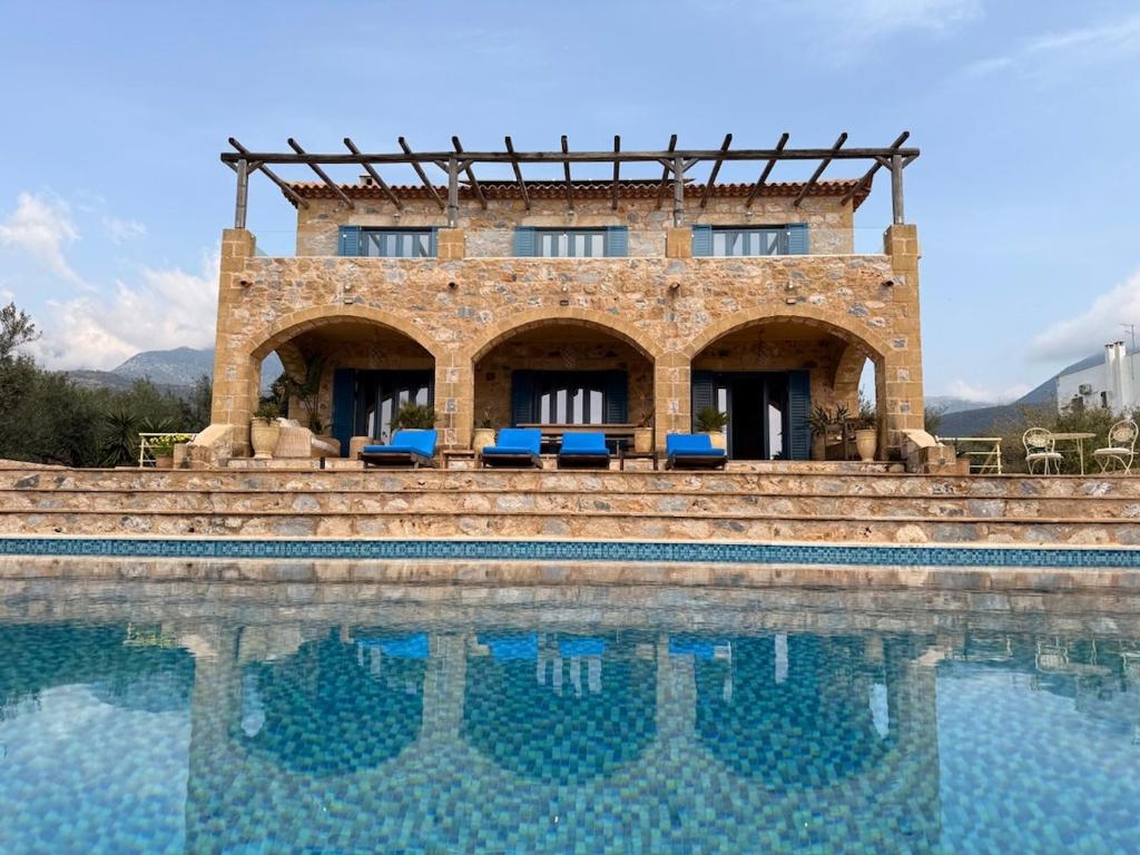 a building sitting next to a swimming pool at Pantazi Beach House in Kotrónion