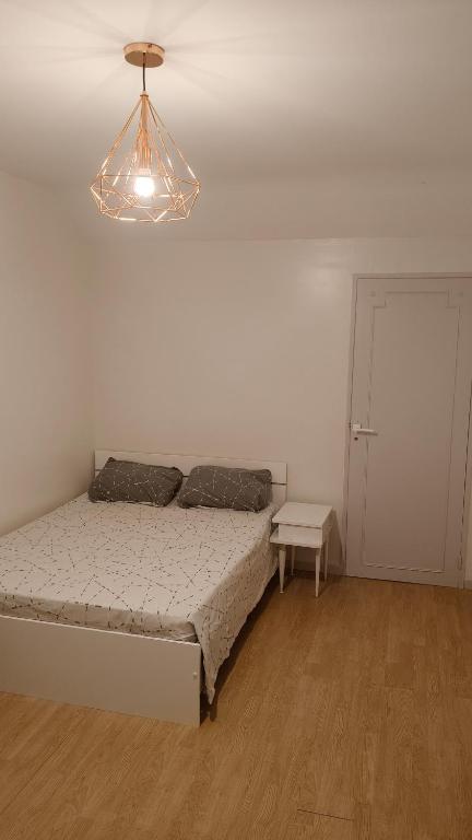 a bedroom with a bed and a light fixture at Chambre Deluxe avec Salle de bain et clim in Bourges