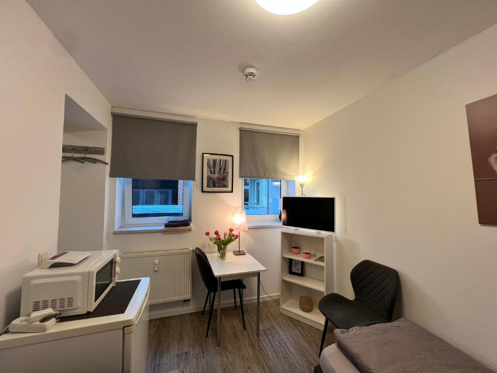 a small room with a desk with a computer and a bed at Cityperle Apartment in Erfurt