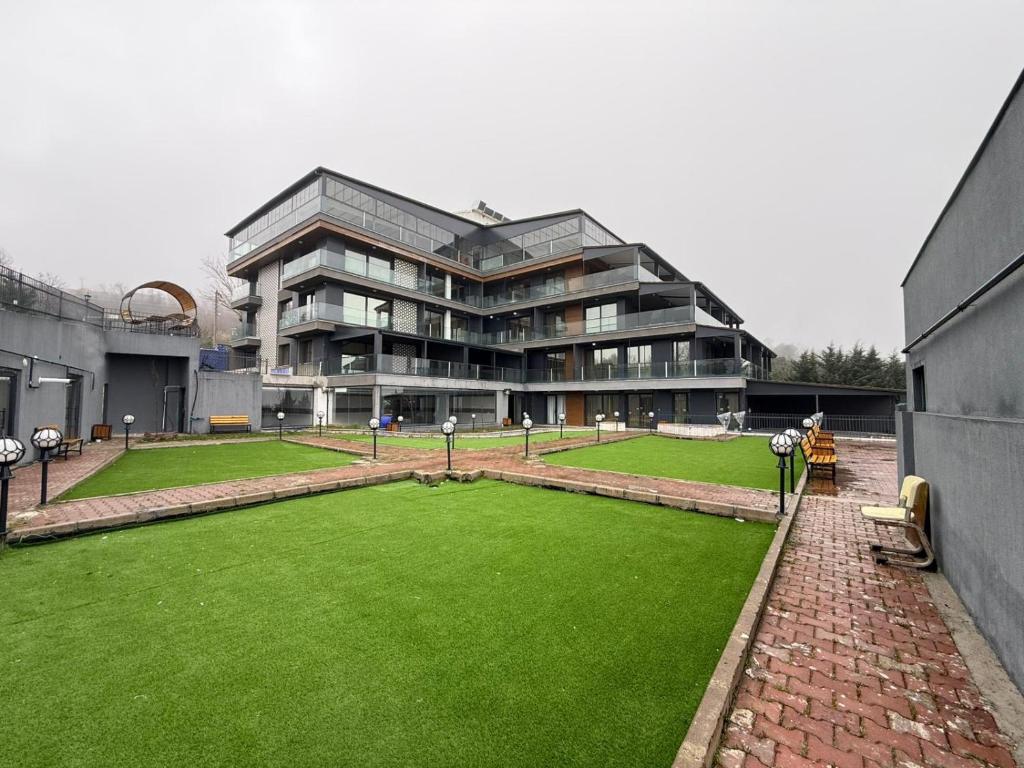 a large building with a green lawn in front of it at Lale Saray Sapanca in Sapanca